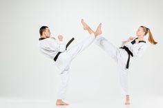 two people doing karate moves in front of a white background