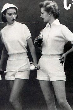 two women standing next to each other holding tennis racquets