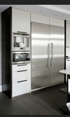 a modern kitchen with stainless steel appliances and white cabinets