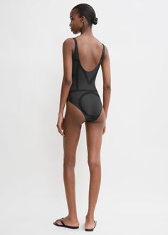 This swimsuit is printed with TOTEME's signature monogram pattern in two shades of black. It is made in Portugal from four way-stretch, recycled-polyamide jersey which protects against sun rays, and is shaped to a classic silhouette with a deep U-back. Pack it with the Monogram jacquard beach towel for your next vacation. Modern Black Stretch Bodysuit, Black Stretch Bodysuit In Polyamide, Black Stretch Polyamide Bodysuit, Black Second-skin Bodysuit For Beach, Black Second-skin Fit Bodysuit For Beach, Black Second-skin Bodysuit For The Beach, Black Nylon Swimwear For Swimming, Black Swimsuit Bodysuit Second-skin Fit, Compressive Polyamide Swimwear For Summer