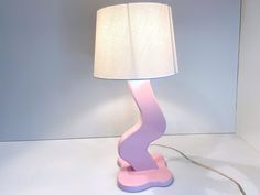 a pink and purple lamp with a white shade