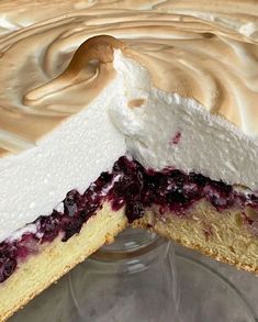 a cake with white frosting and blueberry topping