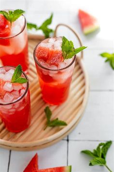 watermelon and mint mojitas on a tray with slices of watermelon