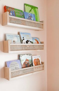 three wooden shelves with books on them against a wall in a child's room