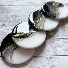 three black and white plates sitting on top of a wooden table