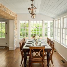 the dining room table is set with place settings for eight people and has windows to let in natural light