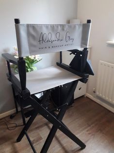 a black and white chair with a sign on it that says aldersburg city hair & makeup artist