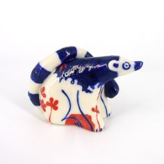 a blue and white ceramic animal figurine on a white background