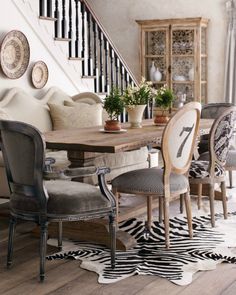 an elegant dining room with zebra rugs on the floor and wooden table surrounded by chairs