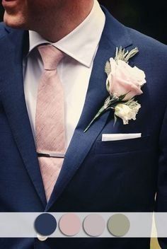 a man in a blue suit with a pink rose on his lapel and white flowers