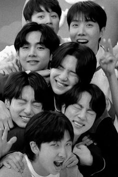 black and white photo of group of young men smiling at the camera with their arms around each other