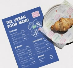 the urban food menu is displayed on a paper plate with croissants in it