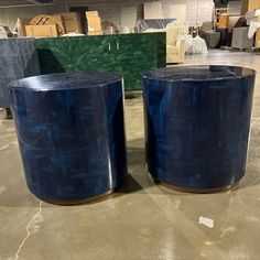 two large blue stools sitting on top of a floor next to each other in a warehouse