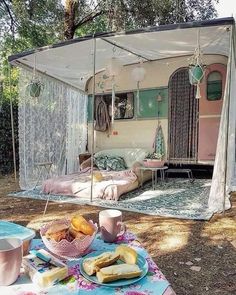 a table with food and drinks on it in front of a campervane