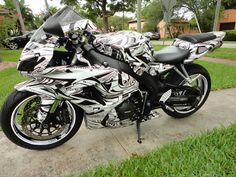 two black and white motorcycles are parked on the sidewalk