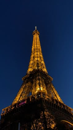 the eiffel tower lit up at night with lights on it's sides