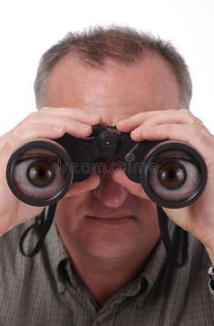 a man looking through binoculars with his hands on the lens royalty images and clippings