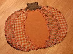 a patchwork pumpkin sitting on top of a wooden floor