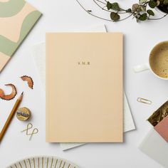 an open notebook sitting on top of a table next to other office supplies and decorations