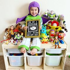 a young boy sitting on top of a wooden shelf holding a sign that says you got a friend in me best friend due to toy story book