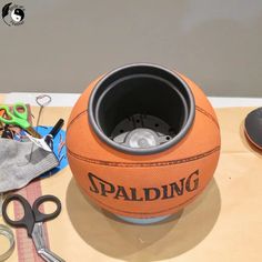 an orange basketball sitting on top of a table next to scissors and other craft supplies