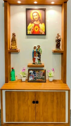 a wooden shelf with statues and pictures on it