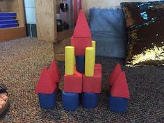 a child's sand castle sits on the floor next to a pair of sandals