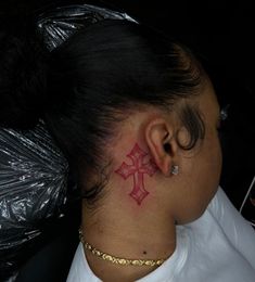 a woman with a red tattoo on her neck and behind her ear is a black plastic bag