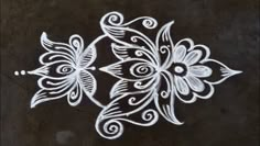 an intricately designed design on the ground in white chalk, with black and gray background