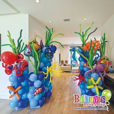 some balloons are in the shape of fish and seaweed on display at a party