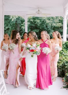 the bride and her bridesmaids are walking down the aisle together in pink dresses