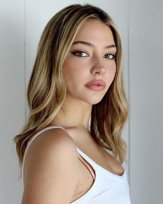 a beautiful young woman in a white tank top