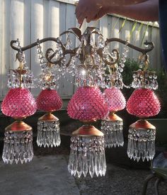 a pink chandelier hanging from a metal rod