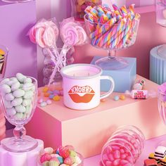 there are many candy and candies on the table with pink walls in the background