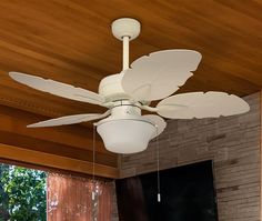 a white ceiling fan hanging from a wooden ceiling