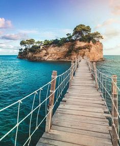 a wooden bridge over the water leading to an island