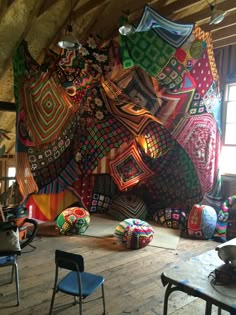 the room is decorated with brightly colored blankets and bean bag poufs on the floor