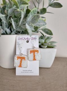 Show your Volunteer pride with these handcrafted Beaded Tennessee Vols Earrings! Featuring the iconic orange 'T' design, these earrings are wire wrapped and silver plated, making them the perfect accessory for any true Tennessee fan. Whether you're gearing up for game day or adding a touch of team spirit to your everyday look, these earrings are a must-have. Handmade with Care: Each pair of these Tennessee Vols Earrings is carefully handcrafted, making every piece truly one-of-a-kind. Due to the handmade nature, the shape may vary slightly from the pictures, adding to their unique charm. Additionally, please note that colors may vary slightly depending on your screen and lighting settings. How to Care for Gold and Silver Plated Jewelry: To keep your gold and silver plated jewelry looking i Tennessee Vols, Glass Beads Jewelry, Jewelry Studio, Silver Plated Jewelry, Wrapped Jewelry, Jewelry Silver, Jewelry Earrings Hoops, Unique Charms, Wire Wrapped Jewelry