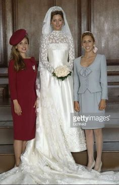 two women and a woman in wedding dresses posing for the camera with their bridesmaids