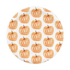 a white plate with orange pumpkins and the word one on it in black lettering