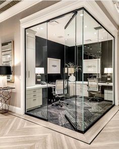 an office with glass walls and desks in the center, surrounded by wooden flooring