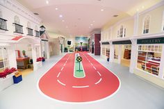 an indoor shopping mall with red carpet and white walls