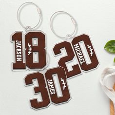 two brown and white key chains with numbers on them