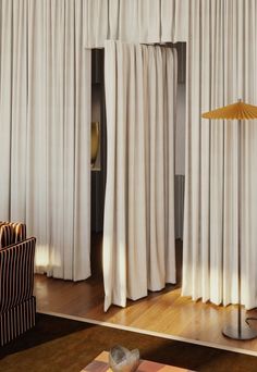 a living room filled with furniture and white curtains