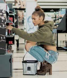 a woman squatting on the floor in front of a machine with writing on it