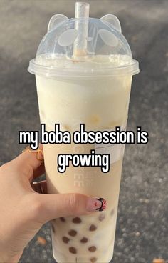 someone holding up a drink with the words my boba possession is growing on it