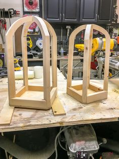 two wooden arches sitting on top of a workbench in a shop or workshop