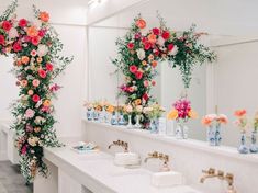 there are many flowers on the wall in this bathroom, and one is decorated with greenery