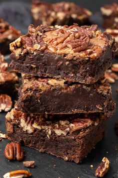 chocolate pecan brownies stacked on top of each other with pecans around them