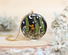 I bring to you this forest necklace with a real mushroom and leaf 🍄🌿 It's not just any moon and star necklace; there's a lot of magic and tenderness in its creation. Join me, and I'll tell you:  All the natural elements you can see in this pendant are indeed natural -except for the moon and stars, obviously 😅-. In my Nature Lover Jewelry, I use flowers and leaves collected with great love and respect for our Mother Nature. That's how I crafted this beautiful terrarium: 1.18 inches in diameter Magical Jewelry Pendants, Pixie Cup Lichen, Nature-inspired Necklace With Moon Charm Round Pendant, Whimsical Mushroom Design Necklace For Gift, Jewelry Mushroom, Stars Making, Mushroom Terrarium, Nature-inspired Round Resin Pendant Jewelry, Nature-inspired Resin Round Pendant Necklace